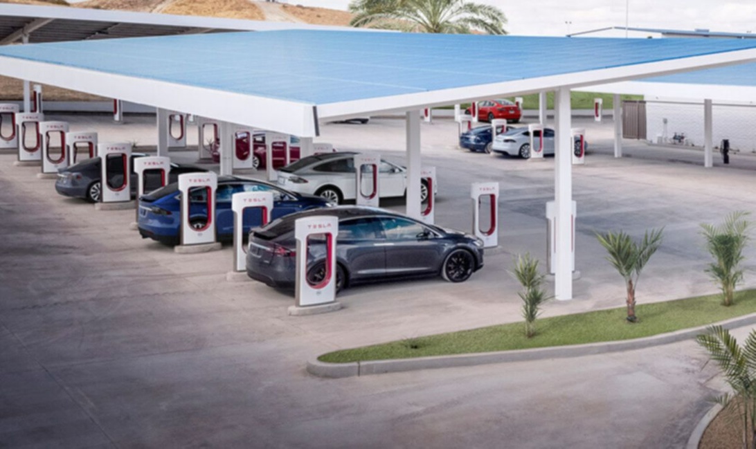 Tesla Supercharger -latausasema aurinkopaneelikatoksen alla, useita Tesloja latauksessa.